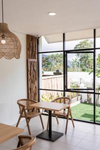 ein Esszimmer mit einem Tisch und Stühlen sowie einem großen Fenster in der Unterkunft Kabinku Bali in Bedugul