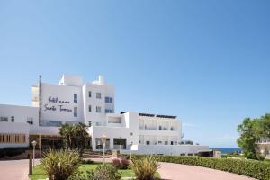 a white building with the ocean in the background at Seth Santo Tomás in Santo Tomás