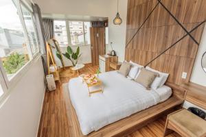 een slaapkamer met een groot bed met een houten hoofdeinde bij The Morris Dalat Hotel in Da Lat