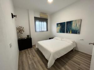 サンルカル・ラ・マヨールにあるJojuの白いベッドルーム(ベッド1台、窓付)