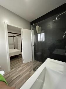 a bathroom with a bath tub and a bedroom at Joju in Sanlúcar la Mayor +33 photos