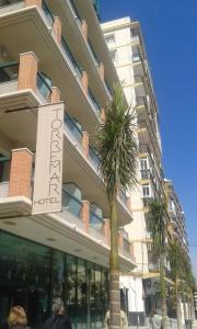 um edifício com uma palmeira em frente em Hotel Torremar - Mares em Torre del Mar