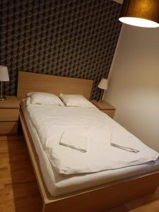 a bed with white sheets and two pillows at Fregata 16 in Jastrzębia Góra