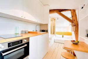 a kitchen with a counter and a table in a room at Le Petit Amerval - Charmant studio climatisé in Nancy