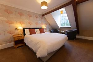 a bedroom with a large white bed and a window at Woodlands Lodge Hotel in Bartley