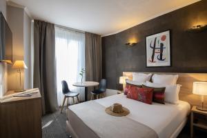 une chambre d'hôtel avec un lit et une table dans l'établissement Amarante Cannes, à Cannes