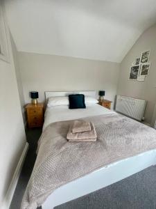 a bedroom with a white bed with a towel on it at Entire 2 bed cottage - Llangwm in Llangwm