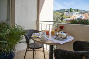a table on a balcony with a breakfast on it at Amarante Cannes in Cannes