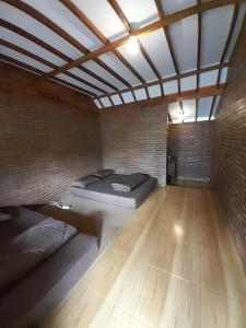 a room with two beds and a brick wall at Avrila Ijen Guest House in Licin