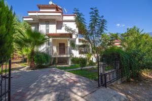a white house with a gate in front of it at Brookland Paris, Özel Havuzlu, Fethiye in Fethiye