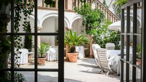 a table and chairs in a courtyard with plants at Hotel Opera in Munich