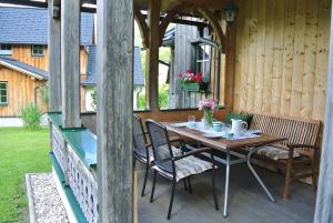 una mesa de madera y sillas en un patio en Ferienhaus Archkogl, en Grundlsee