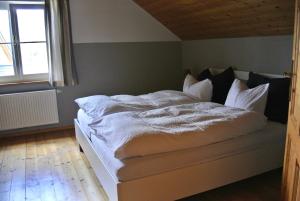 a bedroom with a bed with white sheets and a window at Ferienhaus Archkogl in Grundlsee