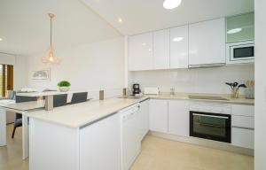 a kitchen with white cabinets and a counter top at Residentie GALA in Orihuela