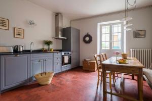 a kitchen with a table and a dining room at La Marcotte - Pierres d'Histoire in Saint-Martin-en-Bière