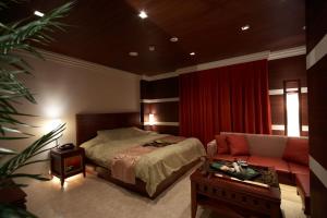 um quarto com uma cama, um sofá e uma mesa em Le Ciel Spa & Resort -Adlt only- em Tsurugashima