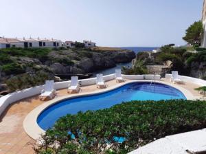 a swimming pool with a view of the ocean at BINIFORCAT in Cala en Forcat