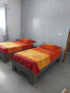 two beds with colorful covers in a room at Keur M et M in Saly Portudal