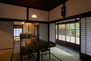 a dining room and living room with a table and chairs at Shirafuji in Suzaka