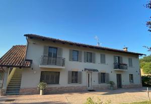 Casa blanca con porche y balcón en Villa Poggio, flat with swimming pool, en Costigliole dʼAsti