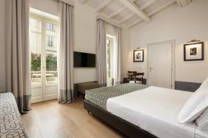 a hotel room with a bed and a television at Hotel Orto de' Medici in Florence