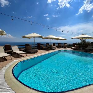 een zwembad met stoelen en parasols op een resort bij KAZDAĞLARI ZEYTUNİHAN BUTİK OTEL in Edremit
