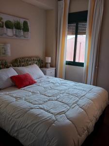 サアラ・デ・ロス・アトゥネスにあるApartamento Zahara De Los Atunesのベッドルーム(赤い枕と白い大型ベッド付)