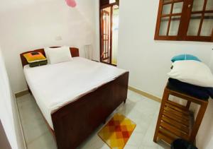 Dormitorio pequeño con cama y mesa en Daban Homestay Ella, en Ella