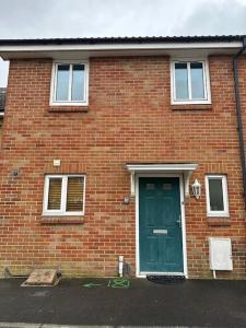 a brick house with a green door and windows at Bilborough House - Comfy furnitures, Free Wifi and Free Parking in Swindon
