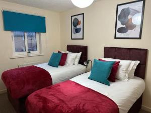 two beds sitting next to each other in a room at Bilborough House - Comfy furnitures, Free Wifi and Free Parking in Swindon