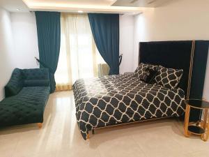 een slaapkamer met een bed, een bank en een stoel bij Pearl of properties in Lahore