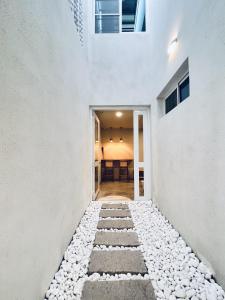um corredor de uma casa branca com uma passagem de pedra em 河趣泊旅 River Chill Inn em Tainan