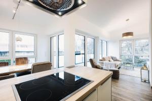 a kitchen and living room with white walls and windows at Kranichruf in Müggenburg