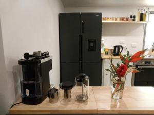 a kitchen with a coffee maker and a black refrigerator at Oasis at Burringbar waterfront holiday 