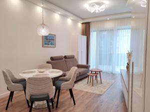uma sala de estar com uma mesa e cadeiras e um sofá em Spa Residence Carbona Water Lily Apartment em Hévíz