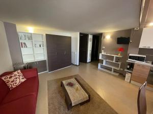 a living room with a red couch and a kitchen at Marconi e Garibaldi 76 apartment in Castellammare del Golfo