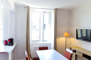 Sainte Catherine - Duplex 1 chambre في بوردو: غرفة مع طاولة بيضاء ونافذة