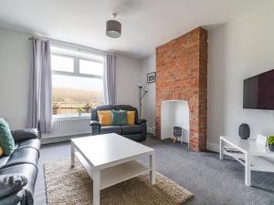 a living room with a couch and a fireplace at East House - 3 bedroom- Stakeford, Northumberland in Hirst