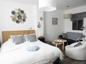 ein Schlafzimmer mit einem weißen Bett und einem Sofa in der Unterkunft La suite Volupté - SPA du Souffle du Saule in Buhl-Lorraine