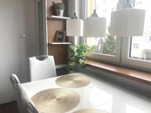 Apartament tuż za rogiem Zamku في مالبورك: طاولة بيضاء مع كرسيين ونافذة