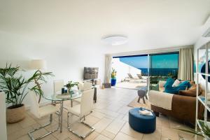 een woonkamer met een bank en een tafel bij FRONTLINE VILLA 25, Modern Coastal Design with Amazing Views in Puerto Calero