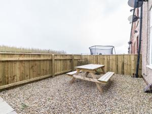 una mesa de picnic en un patio junto a una valla en East House - 3 bedroom- Stakeford, Northumberland en Hirst