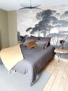 MontsにあるGite de charme au bord de l'Indre avec jacuzziのベッドルーム1室(壁に絵画が描かれたベッド1台付)