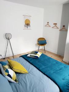 um quarto com uma cama azul e uma cadeira em Gite de charme au bord de l'Indre avec jacuzzi em Monts