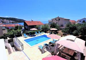 a view of a swimming pool with umbrellas at Luxury beachfront villa with pool for two families in Trogir