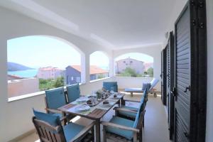 a dining room with a table and chairs and windows at Luxury beachfront villa with pool for two families in Trogir