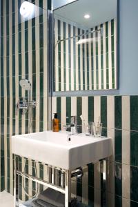 a bathroom with a white sink and a mirror at Hôtel Beauregard in Paris