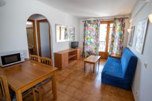 een woonkamer met een blauwe bank en een tafel bij Seth Sa Mirada in Arenal d'en Castell