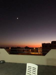une chaise blanche assise au sommet d'un bâtiment avec la lune dans l'établissement Agadir vibes appartement, à Agadir