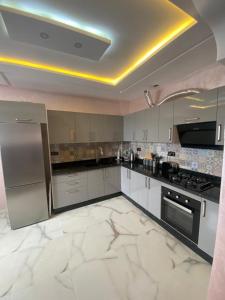 a large kitchen with white marble floors and stainless steel appliances at Agadir vibes appartement in Agadir